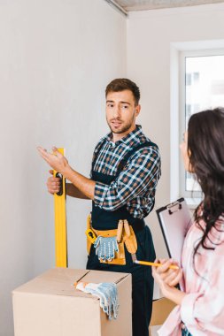 seçici odak el ulağı eller ve Pano kadınla yakınındaki seviyesi ölçümü ve duvara bakarak holding 