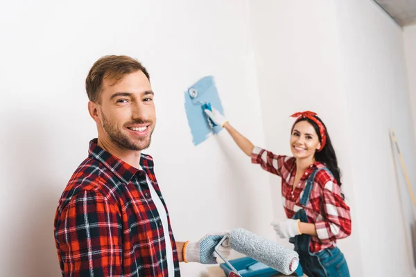 Attractive Woman Painting Wall Blue Color Cheerful Boyfriend Home — Stock Photo, Image