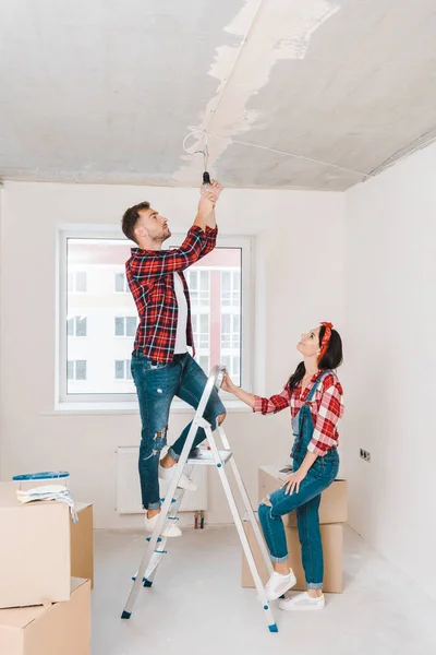 Handsome Man Standing Ladder Changing Light Bulb Attractive Girlfriend — Stock Photo, Image