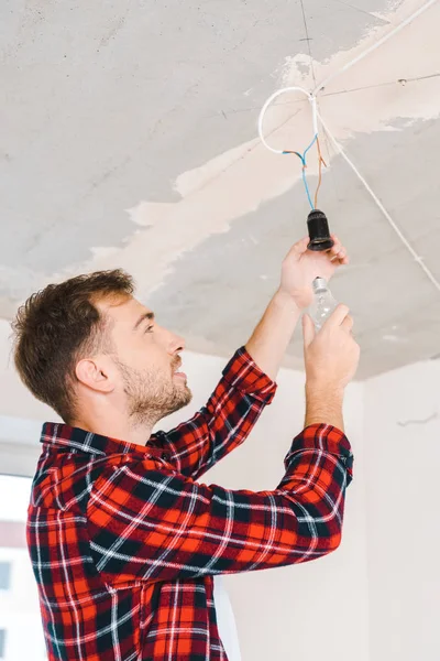 Cheerful Man Changing Light Bulb Home — Stock Photo, Image