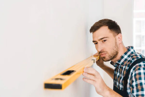 Selective Focus Handsome Handyman Holding Measuring Level Wall — Stock Photo, Image