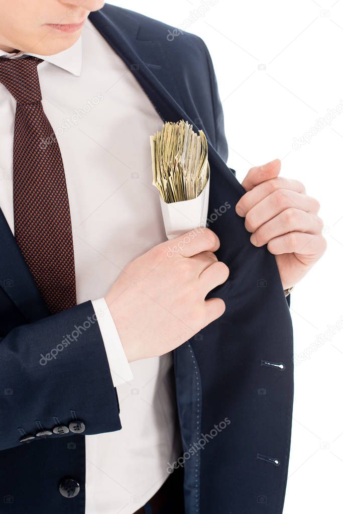 cropped view of young businessman putting bribe into pocket of suit isolated on white