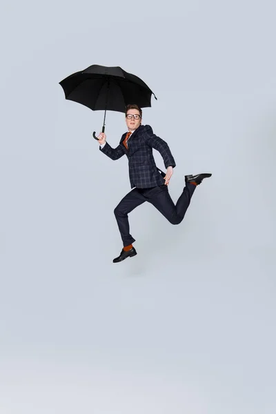 Homem Negócios Elegante Terno Pulando Com Guarda Chuva Isolado Cinza — Fotografia de Stock