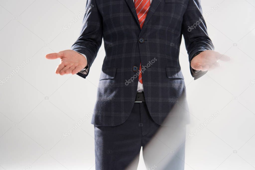cropped view of stylish businessman presenting something on grey