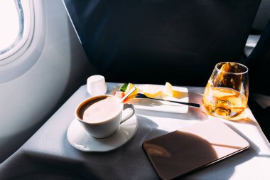 passenger table in airplane with drinks, snacks and digital tablet with blank screen