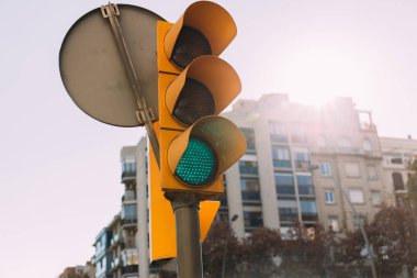 selective focus of traffic light with multistory house on background, barcelona, spain clipart