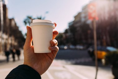 seçici odak erkek el ile kağıt bardak, bulanık kentsel olay yerine arka plan, barcelona, İspanya