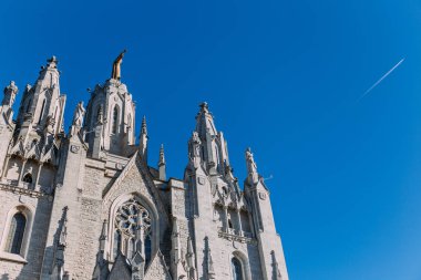 exterior of temple expiatori del sagrat on blue sky background, barcelona, spain clipart