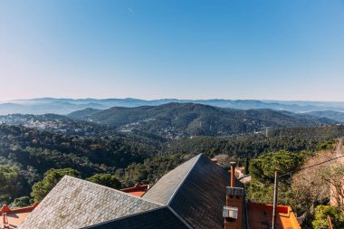 scenic view of houses and hills covered with forest, barcelona, spain clipart
