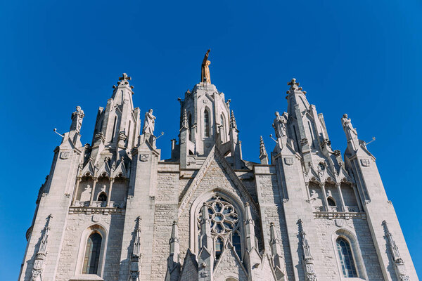  exterior of temple expiatori del sagrat on clear blue sky background, barcelona, spain