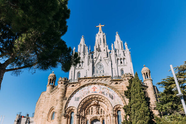 exterior of temple expiatori del sagrat on blue sky background, barcelona, spain