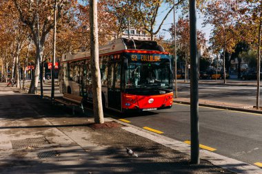 BARCELONA, SPAIN - DECEMBER 28, 2018: city bus moving on wide roadway on sunny day clipart