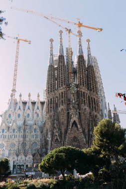 BARCELONA, SPAIN - DECEMBER 28, 2018: selective focus of Temple Expiatori de la Sagrada Familia, one of the most famous buildings of Barcelona, built by Antoni Gaudi, on blue sky background clipart