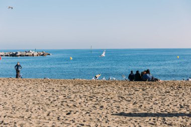 Barcelona, İspanya - 28 Aralık 2018: deniz ve plaj üzerinde oturan insanlar doğal görünümünü 