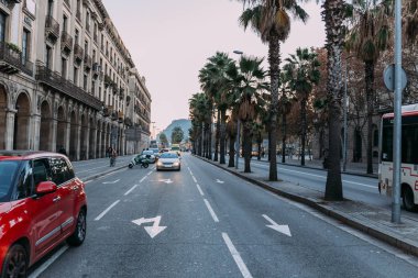 Barcelona, İspanya - 28 Aralık 2018: binalar, palmiye ağaçları ve araçların karayolu üzerinde hareket ile işlek cadde 