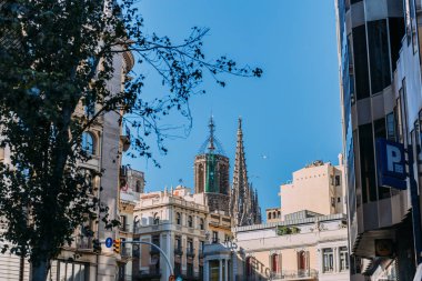 BARCELONA, SPAIN - DECEMBER 28, 2018: urban scene with modern buildings and Temple Expiatori de la Sagrada Familia on background clipart