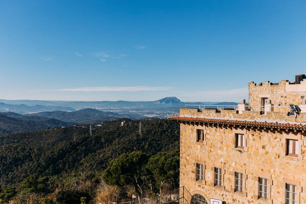 old castle and beautiful view of hills covered with forest, barcelona, spain