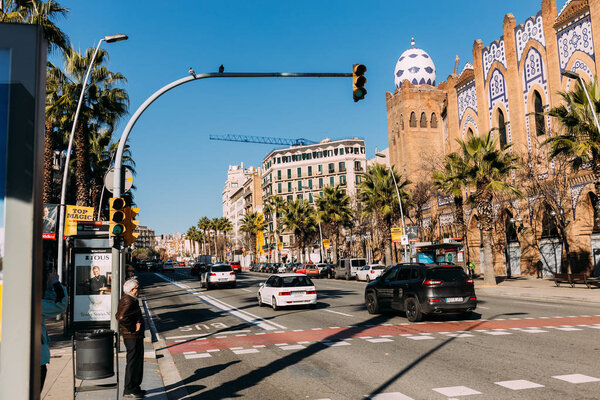 BARCELONA, SPAIN - DECEMBER 28, 2018: busy street with old multicolored building and cars moving on wide road