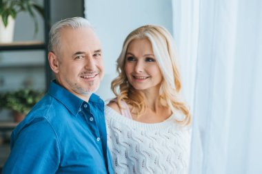mutlu çift evde ayakta iken gülümseyen