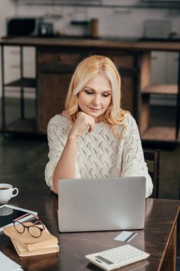 seçici odak dalgın kadının evde laptop oturan