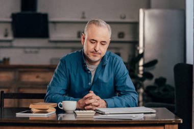 Kitaplar ve dijital tablet yakınındaki içkiyle Kupası'nda görünen yakışıklı adam