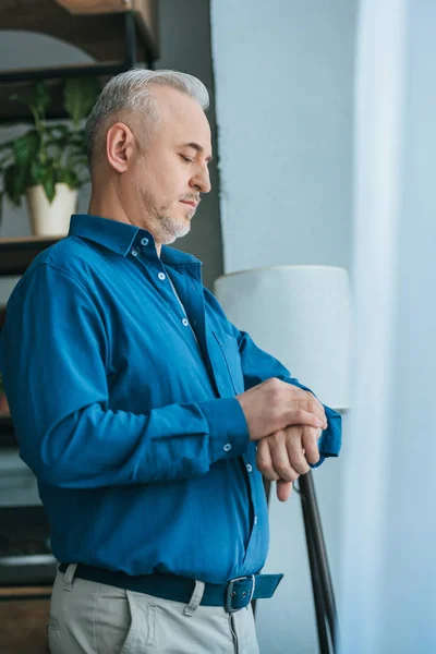 Schöner Mann Schaut Auf Uhr Während Hause Steht — Stockfoto