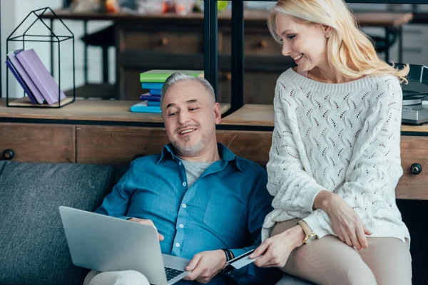 Cheerful Man Looking Laptop Wife Holding Credit Card — Stock Photo, Image