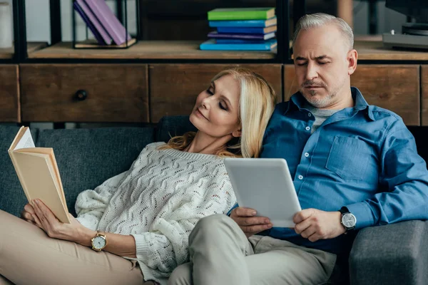 Mutlu Karısı Kocası Kanepede Otururken Dijital Tablet Kullanarak Yakın Kitap — Stok fotoğraf