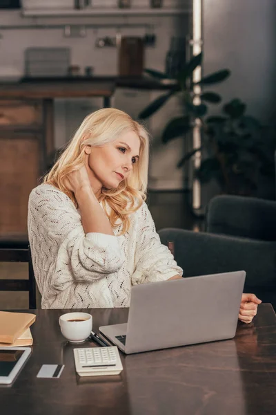 Atrakcyjna Kobieta Dotyka Szyi Pobliżu Puchar Piciem Laptopa Domu — Zdjęcie stockowe