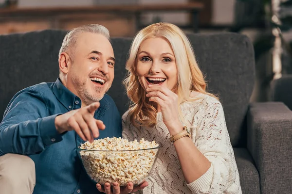 Hombre Feliz Señalando Con Dedo Mientras Sostiene Tazón Con Palomitas — Foto de Stock