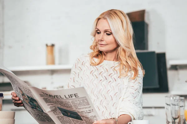 Attractive Blonde Woman Reading Travel Newspaper Kitchen — Stock Photo, Image