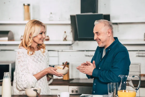 Happy Wife Holding Bowl Cornflakes Cheerful Husband Kitchen — Stock Photo, Image