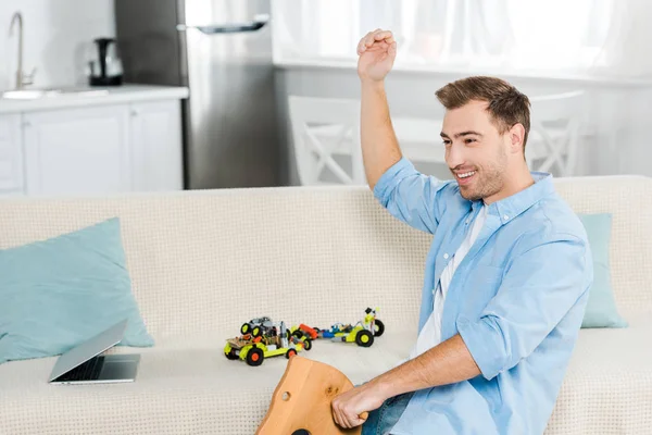 Excited Handsome Man Cheering Riding Wooden Rocking Horse Home — Stock Photo, Image
