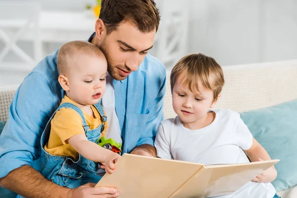 Όμορφος Πατέρας Κάθεται Και Ανάγνωση Βιβλίων Στους Γιους Preschooler Και — Φωτογραφία Αρχείου