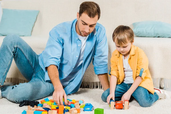 Vater Und Vorschulsohn Spielen Hause Mit Bunten Bauklötzen Und Spielzeugautos — Stockfoto