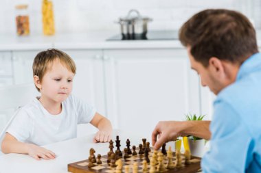 masada oturan ve evde satranç baba ve preschooler oğlu
