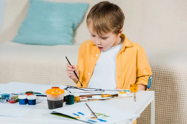 Überrascht Niedlichen Vorschuljungen Zeichnung Mit Pinsel Hause — Stockfoto