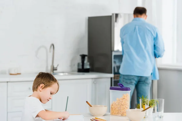 Niño Preescolar Dibujo Durante Desayuno Con Padre Fondo Cocina — Foto de Stock