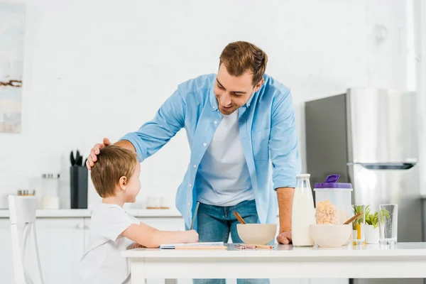 Smiling Father Stroking Preschooler Son Breakfast Kitchen — Stock Photo, Image