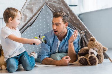 sürpriz baba preschooler oğlu oyuncak araba Kızılderili çadırı evde altında oynamaya bakıyor