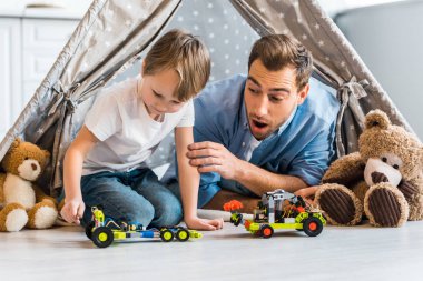 sürpriz baba preschooler oğlu oyuncak araba Kızılderili çadırı evde altında oynamaya bakıyor