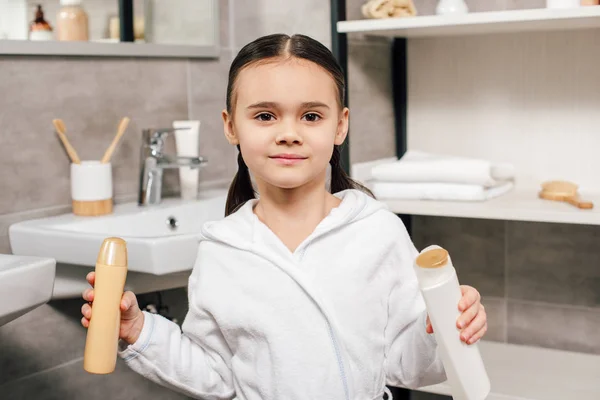 Cute Child White Bathrobe Holding Bottles Shower Gel Bathroom — Stock Photo, Image