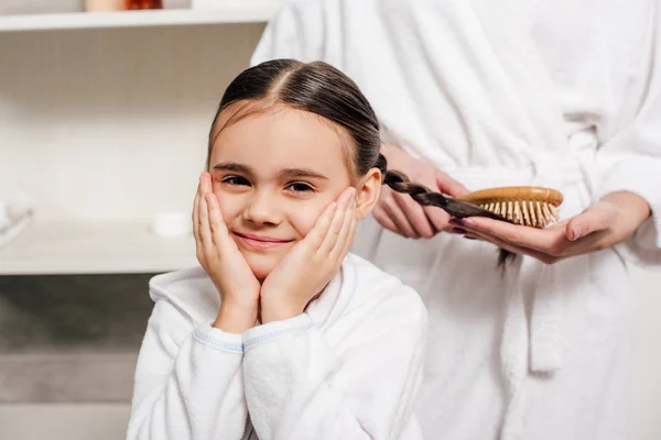 Madre Accappatoio Bianco Pettinatura Figlia Capelli Con Spazzola Legno Bagno — Foto Stock