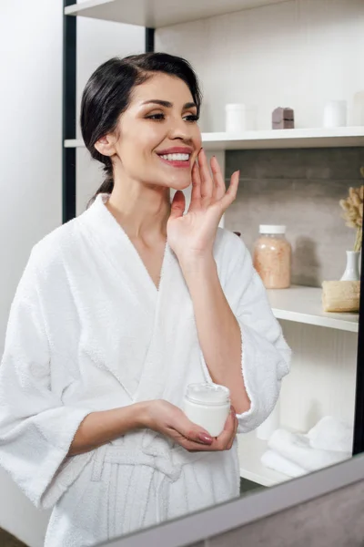 Mulher Roupão Branco Olhando Para Espelho Aplicando Creme Cosmético Banheiro — Fotografia de Stock