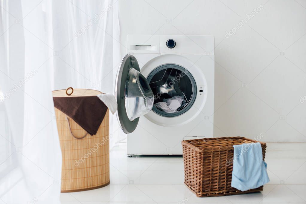 opened washer and brown baskets in laundry room