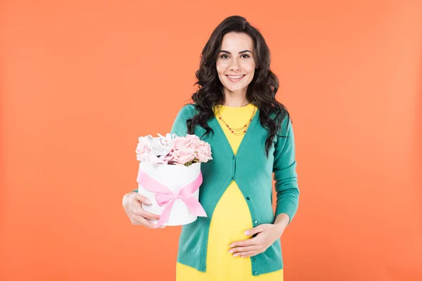 Attractive Pregnant Woman Holding Pink Flowers Touching Belly Isolated Orange — Stock Photo, Image