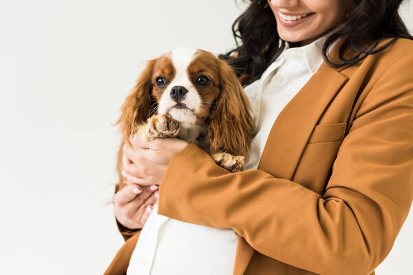 Cropped view of smiling pregnant woman holding dog isolated on white 