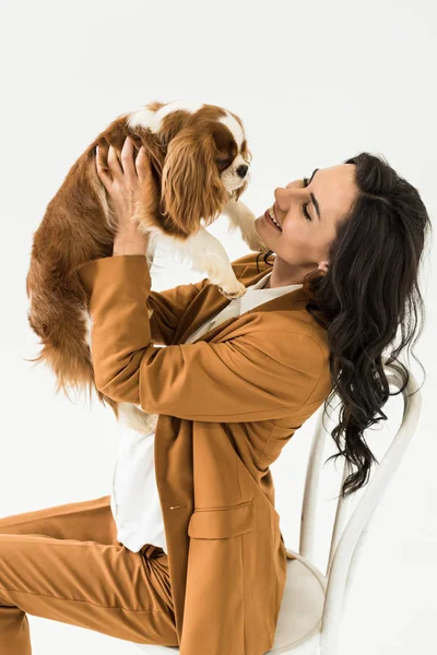 Pregnant curly woman sitting on chair with smile and holding dog isolated on white — Stock Image Pregnant Curly Woman Sitting Chair Smile Holding Dog Isolated White Stock Image