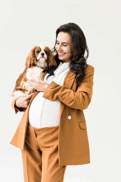 Joyful pregnant woman in suit holding dog isolated on white — Stock Image Joyful Pregnant Woman Suit Holding Dog Isolated White Stock Image