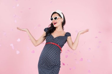 Pink izole konfeti ellerimde sallayarak kaygısız hamile kadın